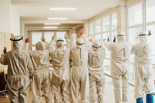 Back View of People in Protective Medical Uniform against Covid-19