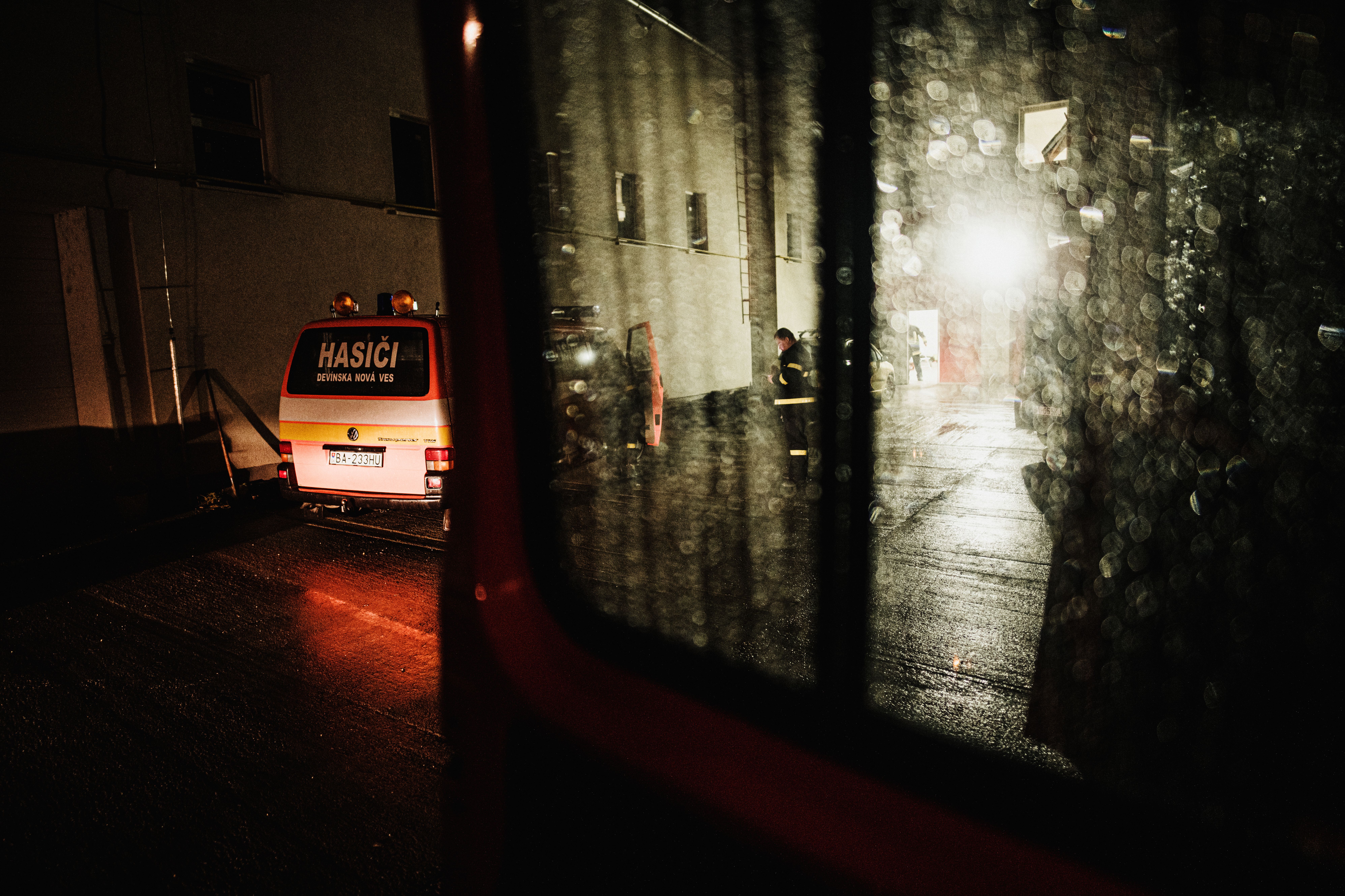 透过雨窗，晚上可以看到一辆消防车，消防员正在行动