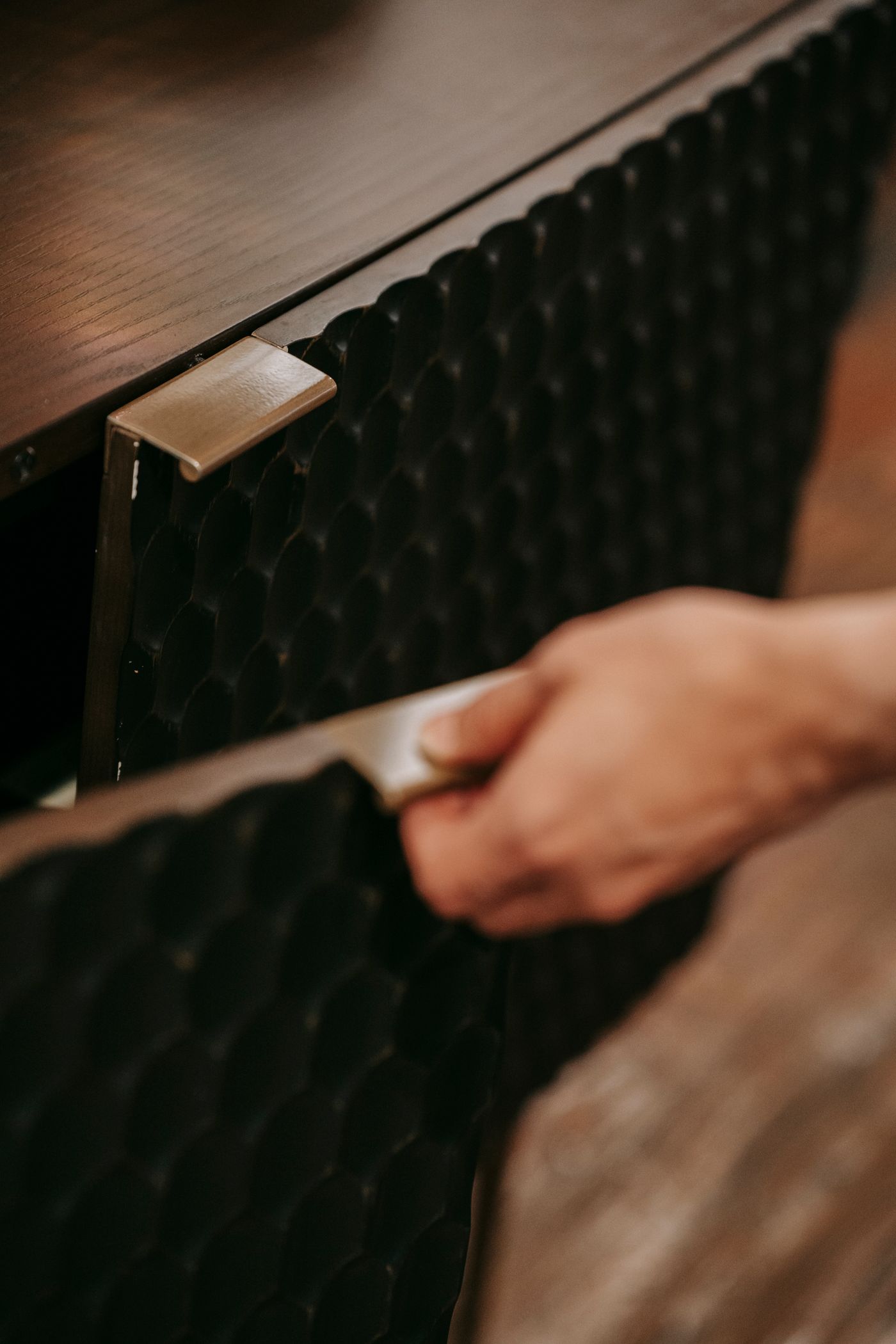 Close up of a cabinet door with raised texture, detailed edges and metal handles