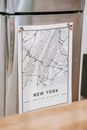Paper map with sketch and United States inscription on refrigerator door near table at home