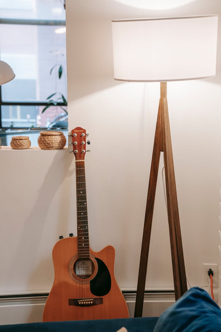 Acoustic Guitar At Wall With Window At Home