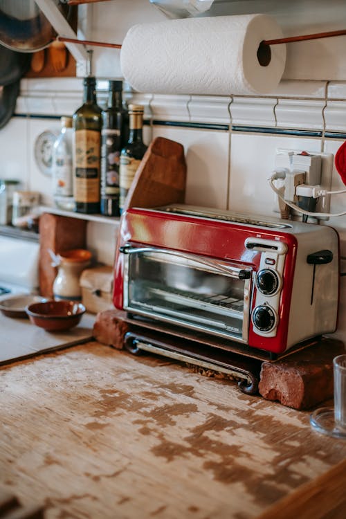 Free Part of kitchen with paper towels and toaster oven standing on old shabby table Stock Photo