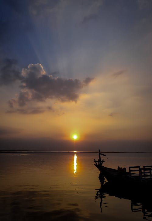 Silhouette of a Boat on Sea at Sunset