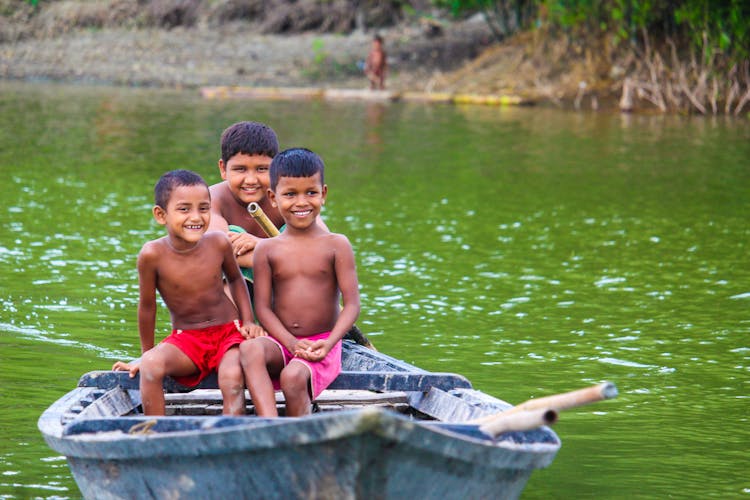 Shirtless Boys Riding A Boat