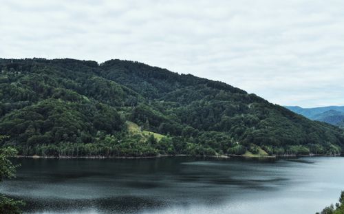 Free Tranquil mountain landscape with lush greenery and a calm lake reflection. Stock Photo