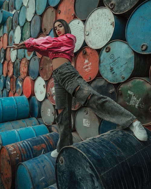 Fashionable ethnic woman standing on barrels