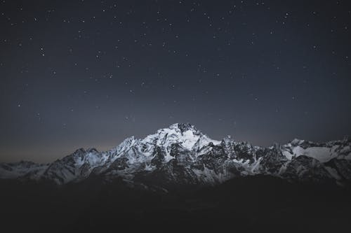 Free Snow Covered Mountain Under Starry Sky during Night Time Stock Photo