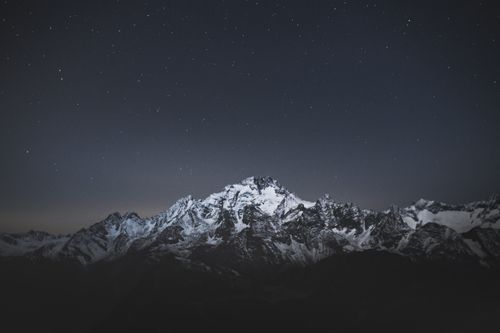 Free Snowy peaks in the Alps under a clear, starry night in Lombardy, Italy. Stock Photo