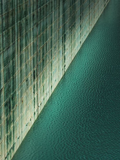 Free Vertical shot of a textured wall reflected in calm water in Lombardy, Italy. Stock Photo