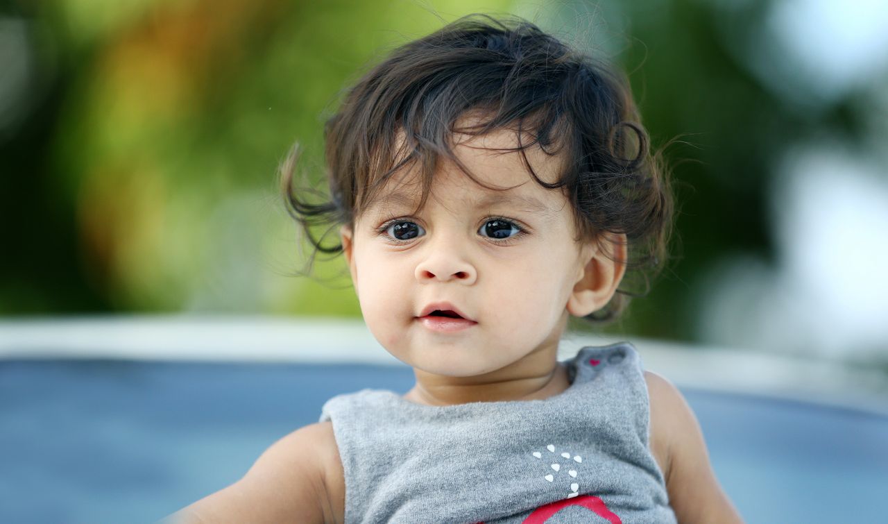 cute portrait of a toddler outdoors with vibrant summer bokeh backgrou