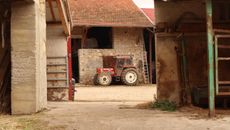 Red and White Tractor in Front of Red Building