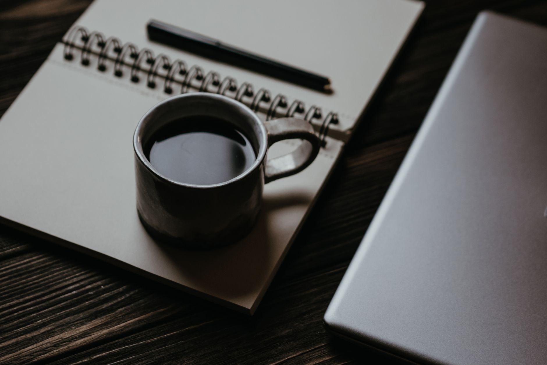 A writer's notebook with pen and coffee