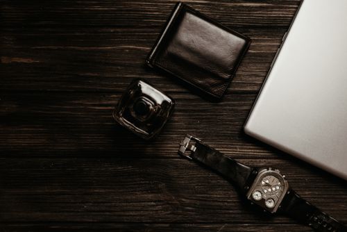Free Stylish flat lay showcasing wallet, watch, and laptop on wooden surface. Stock Photo