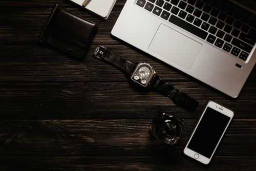 Free Minimalist flat lay of a laptop, smartphone, and accessories on a wooden surface. Stock Photo