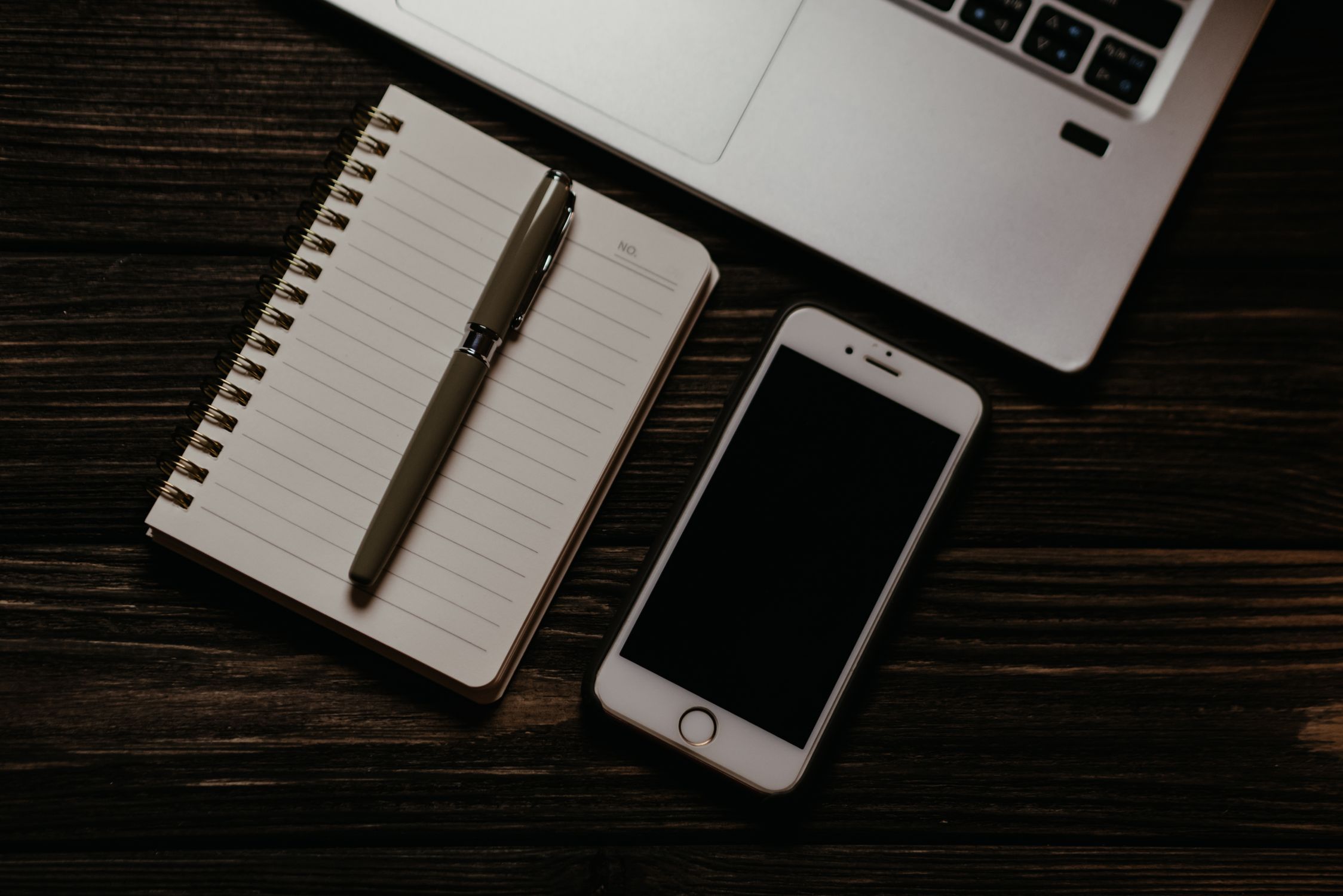 Iphone and Notepad on Wooden Table · Free Stock Photo