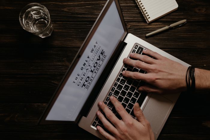 Overhead view of hands typing on a laptop for blog content