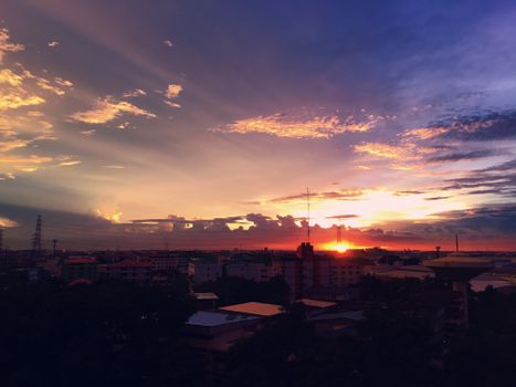 An awe-inspiring sunset over the city skyline with colorful clouds and silhouettes.