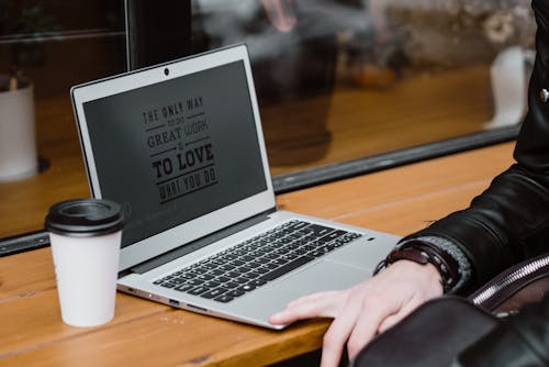 Orang Yang Menggunakan Macbook Air Di Meja Kayu Coklat