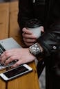 A Person Holding a Coffee While using Laptop