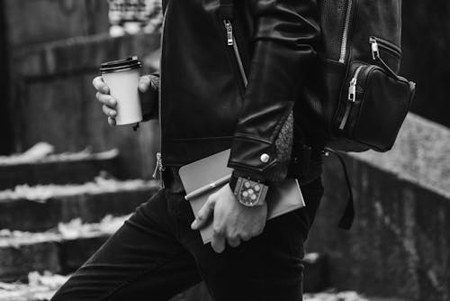 Grayscale Photo of Person Holding a Cup of Coffee