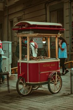 A retro red chestnut cart on a bustling street in Istanbul, Turkey.