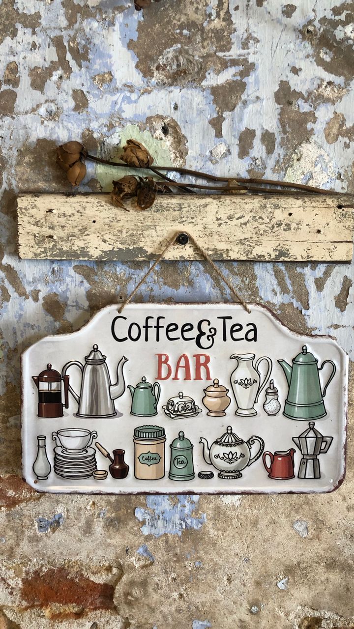 retro metal coffee sign mounted on a kitchen wall above a coffee bar