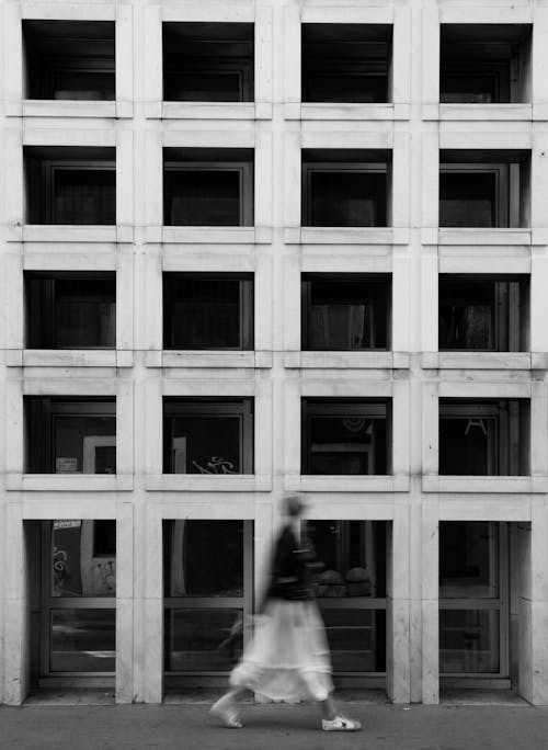 A Woman Walking in front of a Building
