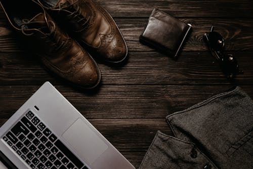 Chaussures En Cuir Noires à Côté Du Macbook Pro