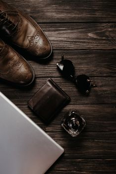 Elegant flat lay showcasing men's leather shoes, sunglasses, wallet, and perfume.