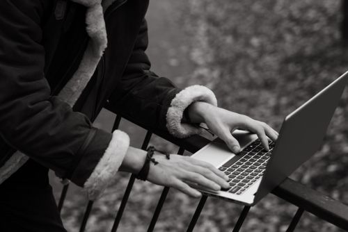 Free A person using a laptop outdoors in fall, reflecting freelance lifestyle and work flexibility. Stock Photo