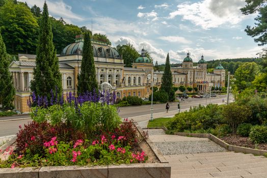 Charming palace facade with manicured gardens and steps in a European town.