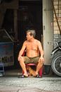 Topless Man in Green Shorts Sitting on Black Motorcycle