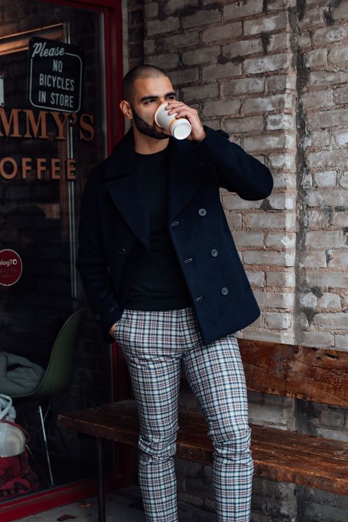 Free Man in stylish plaid pants drinking coffee outside a café. Stock Photo
