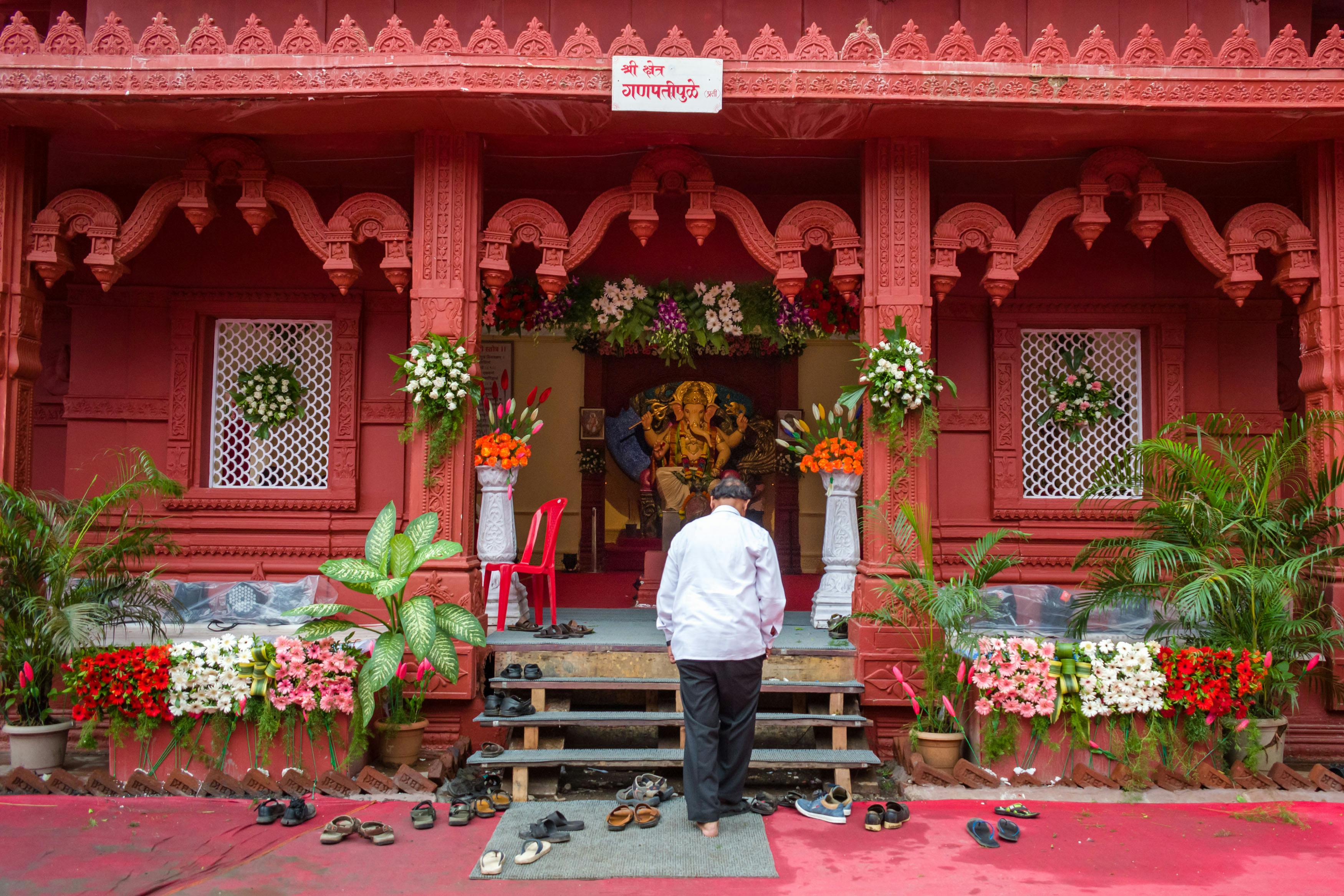 man in white dress shirt and gray pants standing in front of red and white concrete