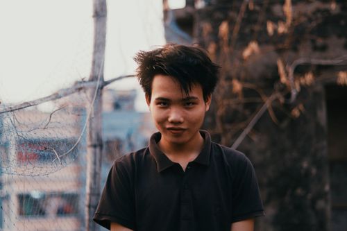 Free Portrait of a young man outdoors with a playful smile and urban background. Stock Photo
