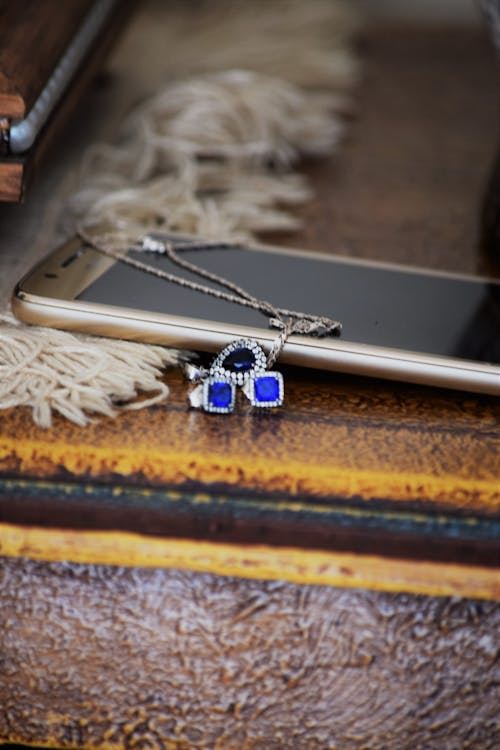 Jewelries Beside a Phone 