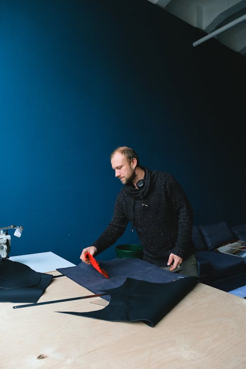 Male tailor working with fabrics in workshop