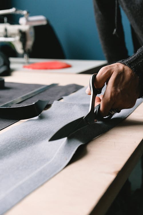 Close up of a Hand with Scissors Cutting a Fabric