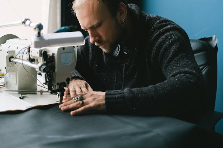 A Tailor Sewing On A Sewing Machine 