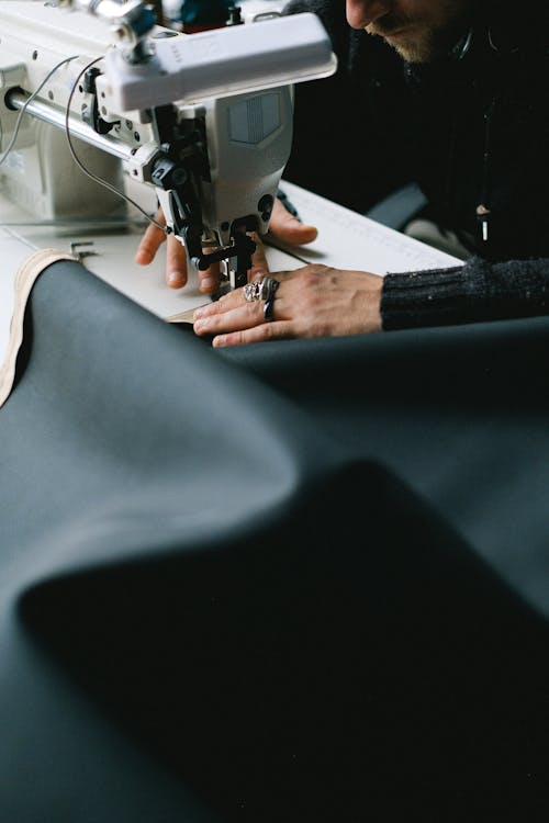 Hands of a Person Sewing Fabric With a Sewing Machine