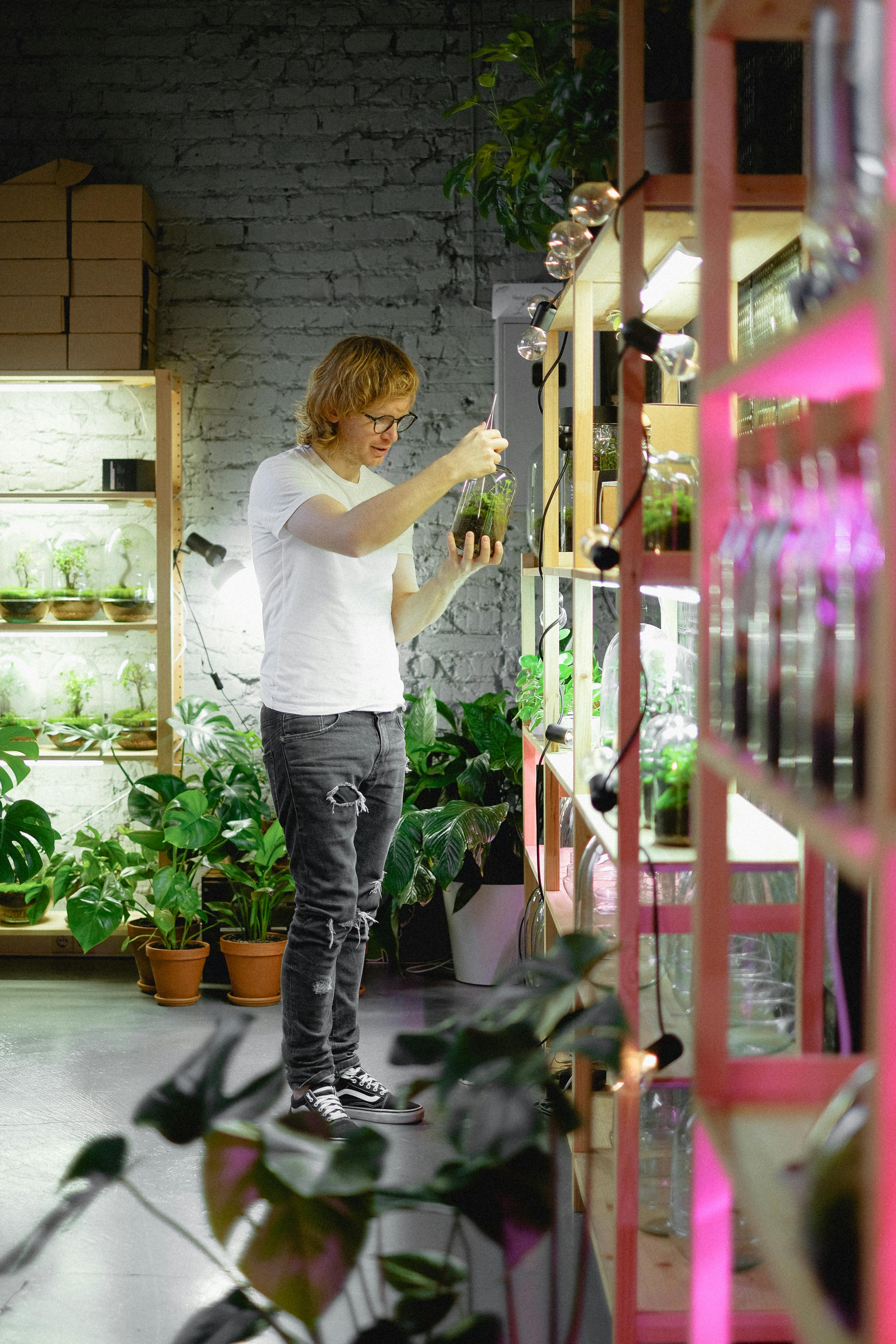 man taking care of plants in greenhouse