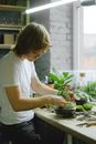 Man in White Shirt Putting the Green Plant on a Clear Glass Bowl