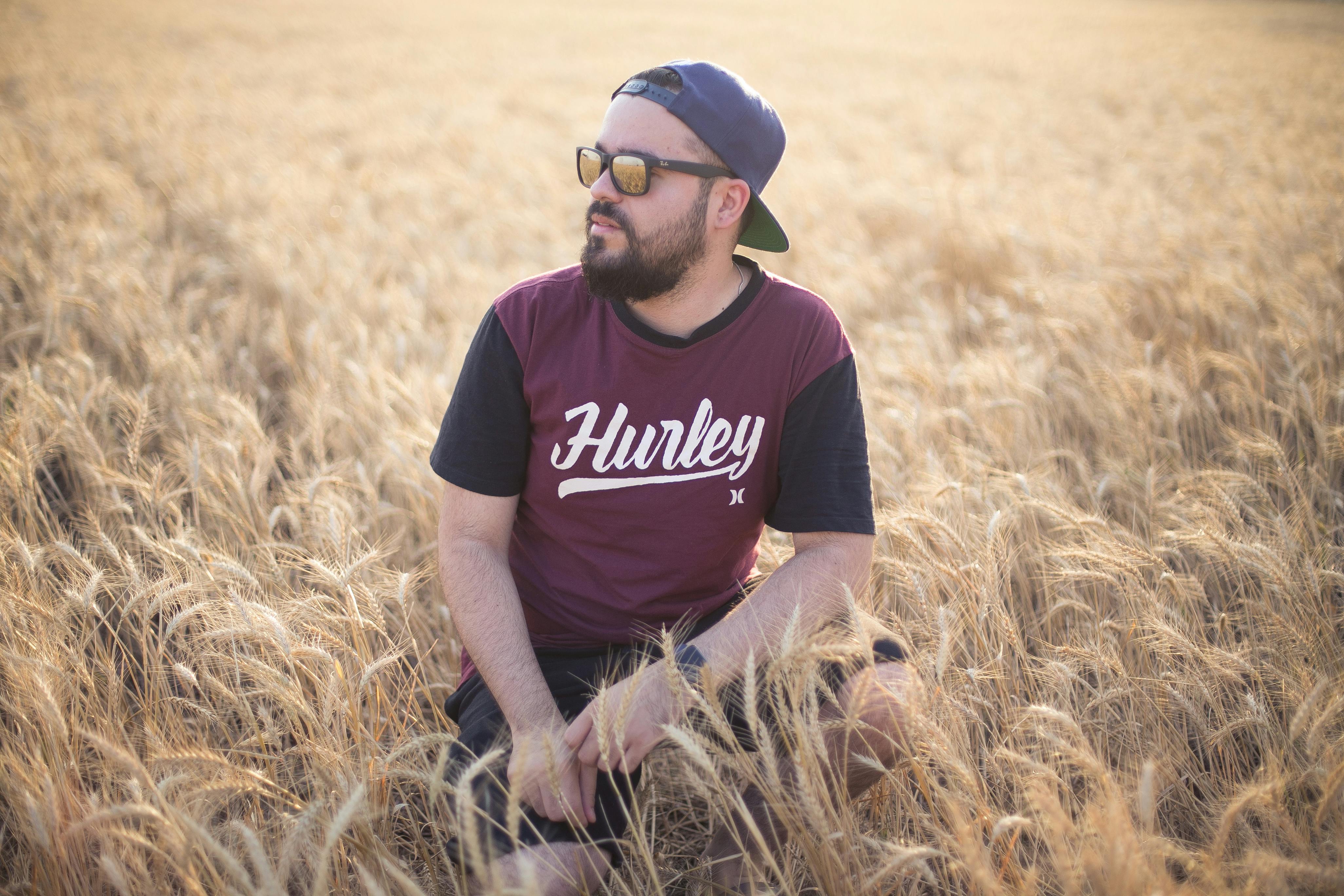 Selective Focus Photography of Man in Crouch Position on Wheat Field · Free Stock Photo