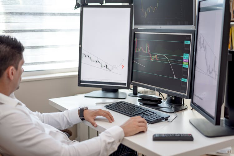 Person In White Long Sleeve Shirt Using Computer