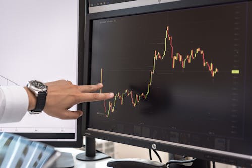 Free Hand on Screen with Charts of Cryptocurrency Stock Photo