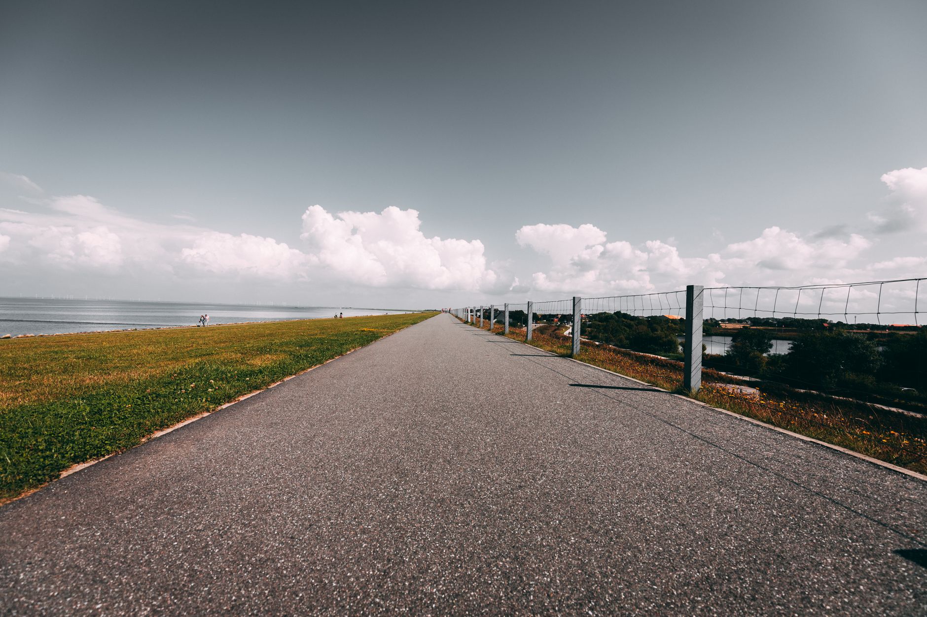 A serene coastal pathway with a clear view of the sea and vibrant skies, perfect for travel inspiration.