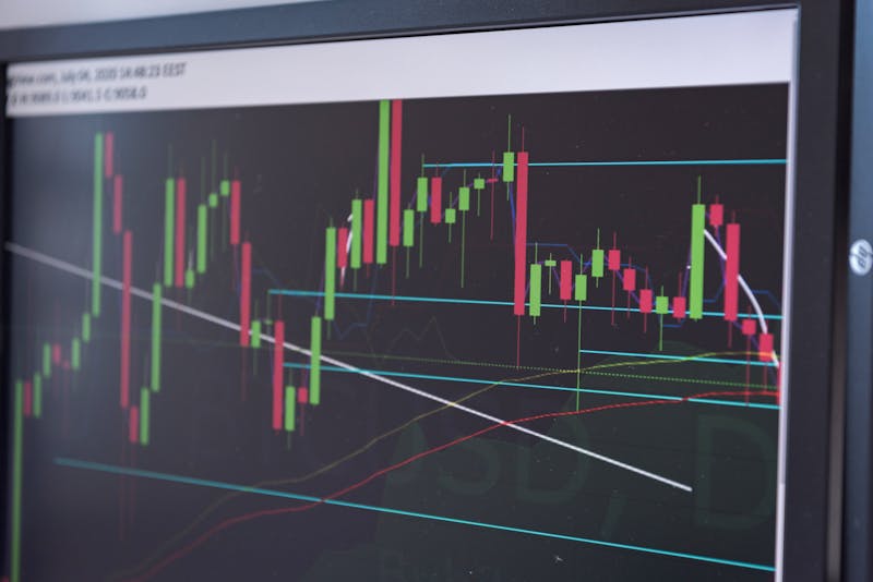 Close-up of a cryptocurrency candlestick chart with technical analysis indicators displayed on a trading monitor