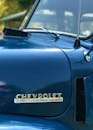 经典雪佛兰卡车引擎盖的详细视图，带有徽标和光泽蓝色油漆
