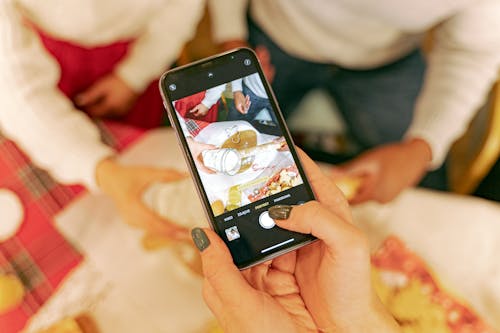 A Hand Taking Photos of the People Baking