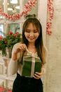 Woman in White Long Sleeve Shirt Holding Green Gift Box